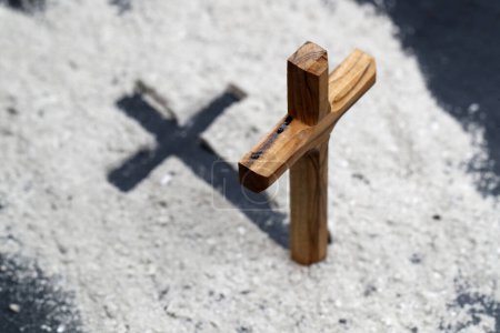 Foto de Cenizas y cruz cristiana de madera. Celebración del Miércoles de Ceniza. Temporada de Cuaresma. - Imagen libre de derechos