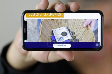 Téléchargez les photos : Collecte de fonds sur un smartphone pour l'église catholique. France. - en image libre de droit