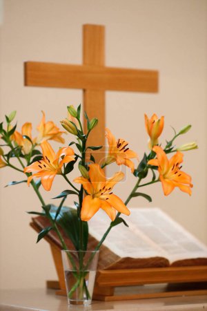 Foto de Iglesia protestante. Abrir la vieja Biblia, flores y cruz de madera. - Imagen libre de derechos