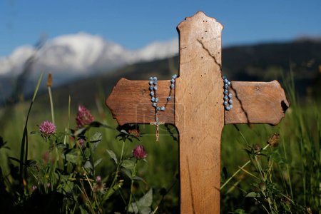 Foto de Cruz cristiana de madera y rosario en la naturaleza. Combloux. Francia. - Imagen libre de derechos