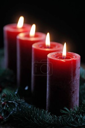 Natural advent wreath or crown with four burning red candles.  Christmas composition.