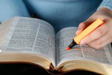 Photo for Woman studying the bible. Close up on hand and highlighter.   France. - Royalty Free Image
