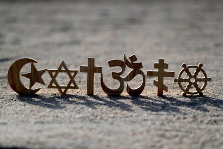 Téléchargez les photos : Symboles religieux sur le sable. Christianisme, islam, judaïsme, orthodoxie Bouddhisme et hindouisme. Concept interreligieux ou interreligieux - en image libre de droit