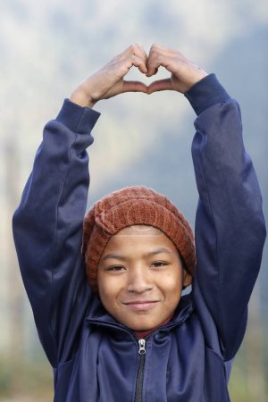 Foto de Centro de rehabilitación para niños de la calle. Retrato. Niño haciendo gestos de manos amor o señal de corazón. Charikot. Nepal. - Imagen libre de derechos