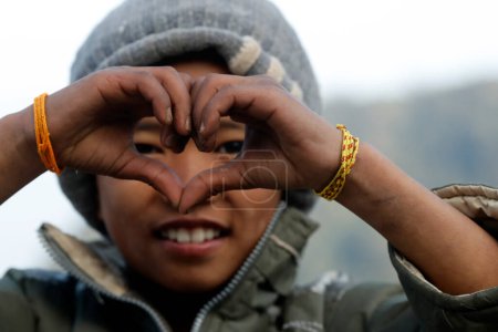 Foto de Centro de rehabilitación para niños de la calle. Retrato. Niño haciendo gestos de manos amor o señal de corazón. Charikot. Nepal. - Imagen libre de derechos