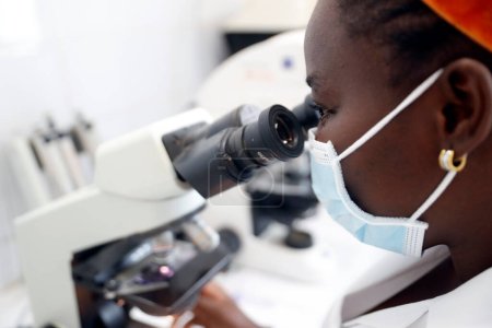 Foto de Biología en un hospital africano. Un técnico de laboratorio que analiza muestras de sangre Benin. - Imagen libre de derechos