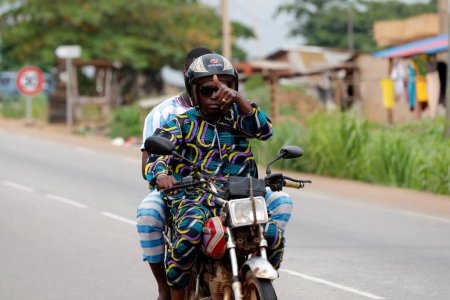 Téléchargez les photos : Scène de rue avec des Africains en moto. Bénin. - en image libre de droit