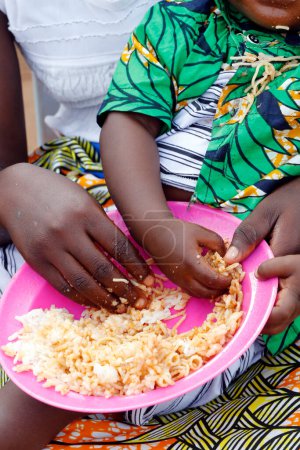 Niños comiendo arroz y fideos en el almuerzo. Benín. 
