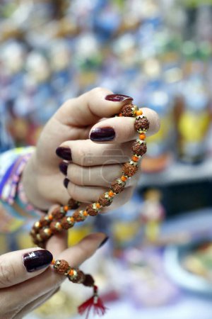 Photo for Hand of prayer holding rudraksha beads or rosary.  Dubai. United Arab Emirates. - Royalty Free Image