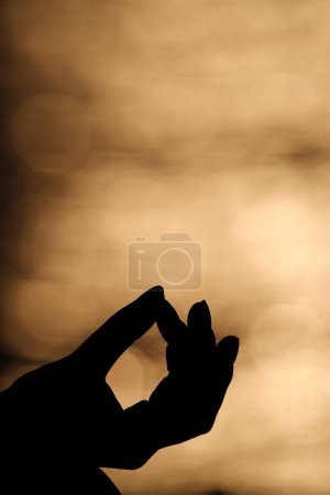Téléchargez les photos : Gros plan main de jeune femme pratique la méditation en position lotus. Yoga au coucher du soleil. - en image libre de droit