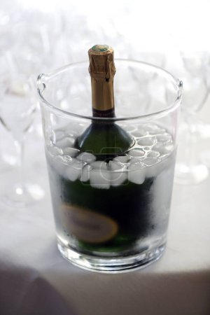 Téléchargez les photos : Fête. Bouteille de champagne dans un seau à glace avec des flûtes sur la table. France. - en image libre de droit