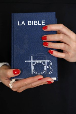 Foto de Mujer con TOB bíblico francés en las manos. Fe y religión. - Imagen libre de derechos