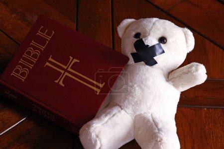 Photo for Bear with tape on his mouth. Symbol of silence on child abuse and victim in christian church. - Royalty Free Image