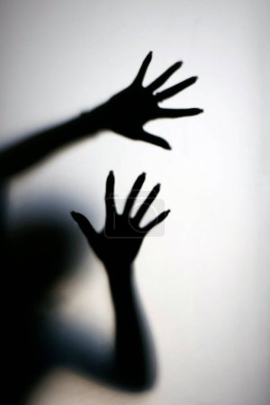 Silhouette einer Frau hinter dem Glas. Frau zeigt Geste Stopp. Stoppt Gewalt und sexuellen Missbrauch gegen Frauen
