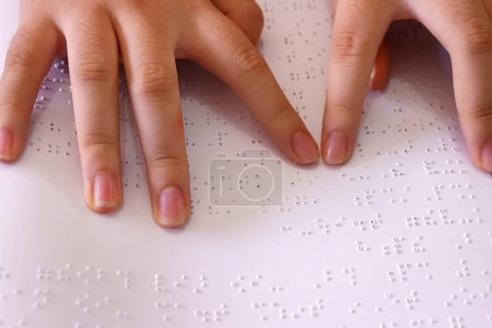 Center for blind children. Blind girl reading braille book Close up on hands.  Ho Chi Minh city. Vietnam. 
