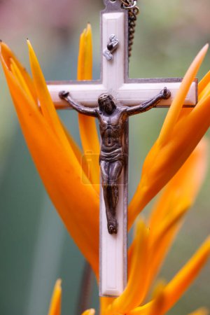 Photo for Crucifix of Jesus on a tropical flower. Pray in nature. - Royalty Free Image