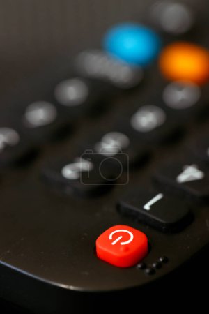 Black remote control to switch channels on the TV.