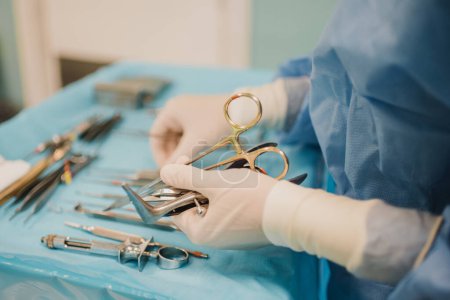 Foto de Nurse doctor preparing surgical equipment for operation inside emergency hospital room - Focus on hand holding scissors - Imagen libre de derechos