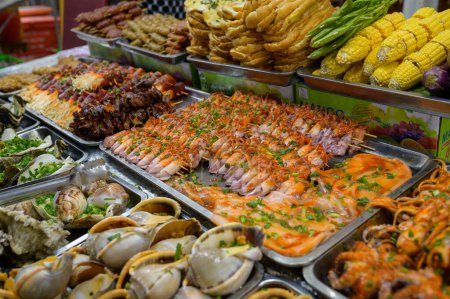 Photo for From above of assorted fresh seafood and boiled corns placed in containers on stall in local bazaar in Vietnam - Royalty Free Image