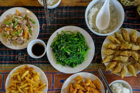 Téléchargez les photos : Vue du dessus de délicieuses algues vietnamiennes et salade placée près des crevettes en pâte et pommes de terre frites sur la table avec sauce soja et riz près des baguettes et des rouleaux de printemps - en image libre de droit