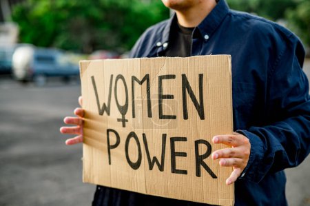 Téléchargez les photos : Cultiver manifestant méconnaissable dans des vêtements décontractés tenant le panneau de carte avec des femmes inscription de puissance tout en se tenant sur fond flou de la rue dans le parc - en image libre de droit
