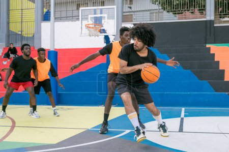 Photo for Full body of African American male basketball player throwing ball in hoop on sports ground - Royalty Free Image