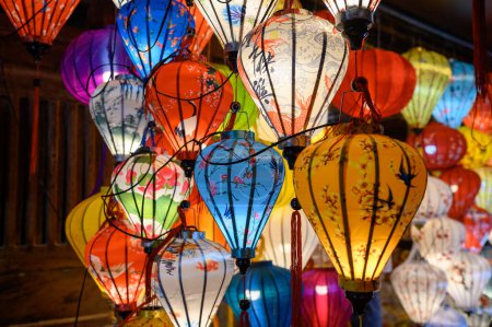Téléchargez les photos : Lanternes colorées avec des décorations orientales ornementales accrochées au mur en bois - en image libre de droit