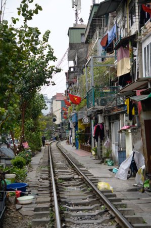 Photo for Surrounded train tracks on a narrow street surrounded by house in Vietnam - Royalty Free Image