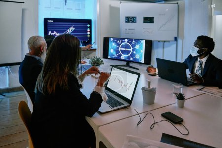 Téléchargez les photos : Un groupe de personnes assis à un bureau avec un ordinateur portable. Photo de haute qualité - en image libre de droit