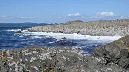 Foto de Un pedacito rocoso de costa en Brunlanes con un cairn de la edad de hierro, o montículo del entierro, visible en el fondo. - Imagen libre de derechos