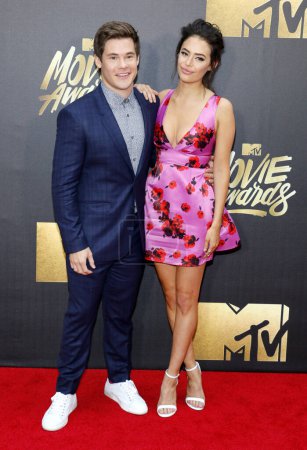 Foto de Adam DeVine y Chloe Bridges en los MTV Movie Awards 2016 celebrados en los Warner Bros. Studios en Burbank, EE.UU. el 9 de abril de 2016. - Imagen libre de derechos
