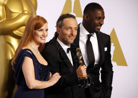 Photo for Emmanuel Lubezki, Jessica Chastain and Idris Elba at the 87th Annual Academy Awards - Press Room held at the Loews Hollywood Hotel  in Los Angeles on Sunday February 22, 2015. - Royalty Free Image