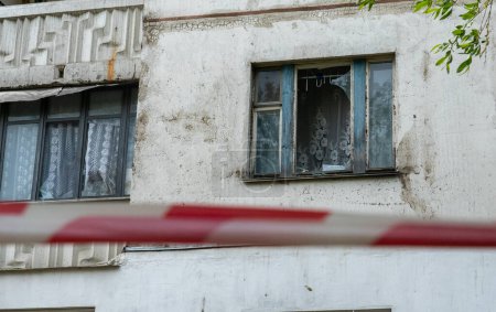 Foto de Vidrio roto en la ventana de apertura de un edificio de apartamentos por una explosión del mayor ataque con cohetes en Kiev, con una cinta de barrera frente a ella, el concepto de la guerra de Rusia contra Ucrania - Imagen libre de derechos