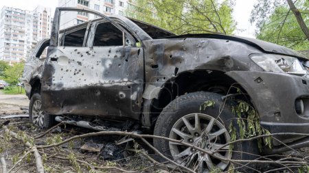 Foto de Coche quemado con agujeros de metralla en el lugar de la explosión después del mayor ataque de misiles de Rusia contra Kiev, el concepto de la guerra de Rusia contra Ucrania - Imagen libre de derechos