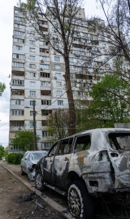 Foto de Un coche quemado con agujeros de metralla frente a una casa con ventanas rotas después del mayor ataque de misiles de Rusia contra Kiev, el concepto de la guerra de Rusia contra Ucrania, el genocidio del pueblo ucraniano - Imagen libre de derechos