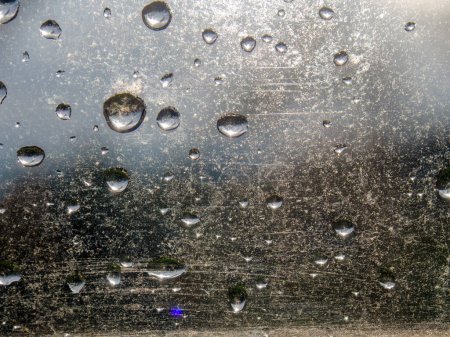 Macro photographie de quelques gouttes de pluie sur une vitre, capturée dans une ferme dans les montagnes andines orientales du centre de la Colombie.
