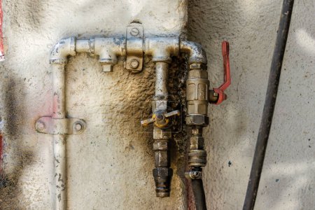 Nahaufnahme eines rustikalen Druckluftverbindungssystems, das an eine raue Wand genagelt wurde, in einer Autowerkstatt in der Stadt Arcabuco in Zentralkolumbien.