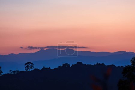 En el último minuto de la puesta del sol, un cielo casi claro está lleno de una hermosa sombra rosa, sobre las montañas andinas orientales del centro de Colombia.