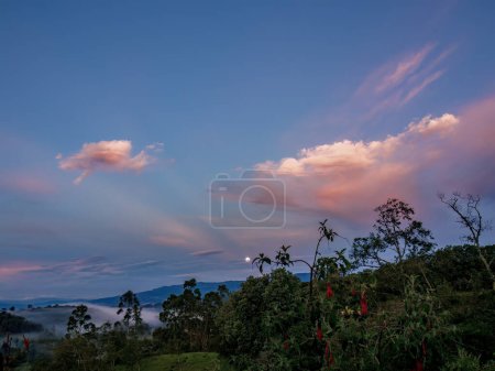 Panoramic view of the beautiful full moon setting over the eastern Andean mountains of central Colombia, at dawn.