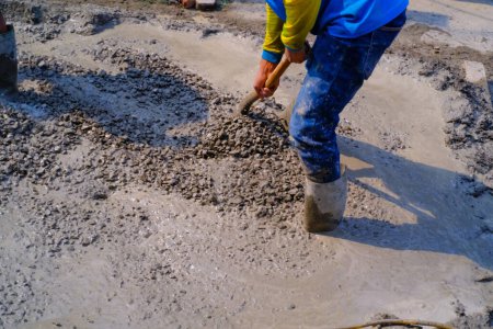 Photo for Industrial Photography. Construction work activities. Workers are hoeing and mixing cement with sand and stones for cement castings. Bandung - Indonesia, Asia - Royalty Free Image
