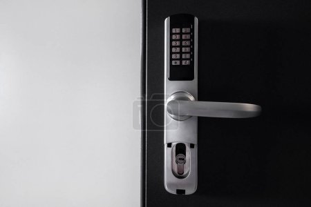 Photo for Door access control. Temporary digital code for opening the room. Close up view of self check in at hotel or apartment. Metal handle with keypad on smart security system against white copy space wall - Royalty Free Image