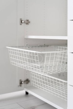 Téléchargez les photos : Empty mesh drawer in wooden closet with open door, Scandinavian minimal storage concept, organized space in dressing room - en image libre de droit
