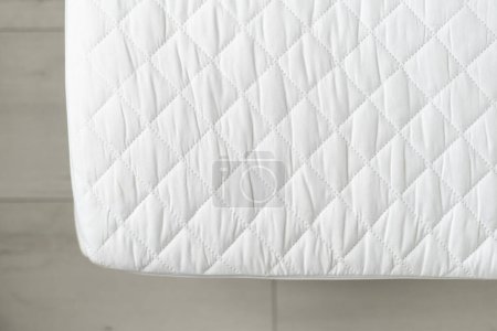 Foto de Vista superior del nuevo colchón ortopédico de la espuma de la memoria con el topper impermeable en la cama en dormitorio, superficie de la protección y tela hipoalergénica - Imagen libre de derechos