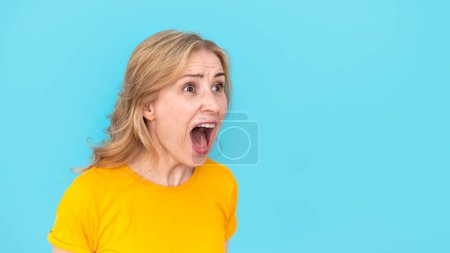 Foto de Banner web de mujer furiosa gritando con la boca abierta, gritando en voz alta aislado sobre fondo azul. Emociones negativas, cara loca y enojada, concepto irritado. Discusión y conflicto. - Imagen libre de derechos