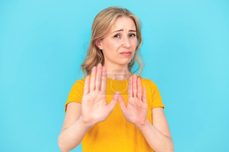 Ew, so gross. Young woman with disgust expression repulsing something. Concept of human reactions and emotions. Female make refuse gesture standing standing isolated on blue background