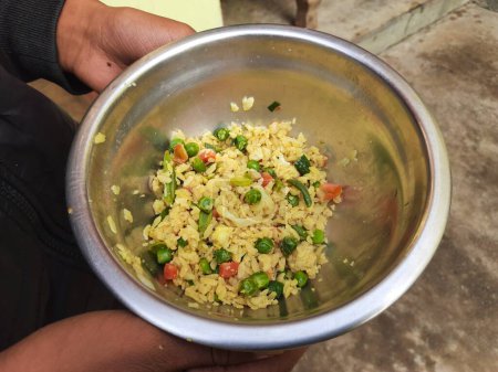 Téléchargez les photos : Poha aux légumes en Inde. Il est fabriqué en mélangeant légumes, poha et épices. Le riz est étuvé avant aplatissement afin qu'il puisse être consommé avec très peu ou pas de cuisson. Petit déjeuner indien. - en image libre de droit