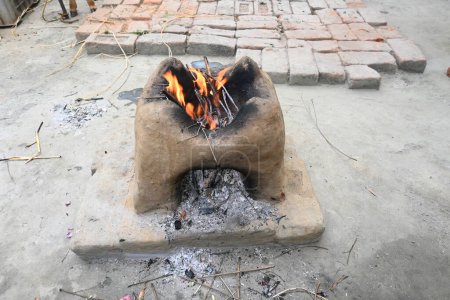 Estufa de arcilla. Este es un tipo de cocina. Se utiliza en el área rural para cocinar y calefacción.Estufas tradicionales utilizadas por los residentes en la India rural. Fuego de leña está ardiendo en la estufa de barro o barro.