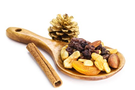 Foto de Mezcla de frutos secos y frutas deshidratadas de Navidad en una cuchara de madera rústica. Nueces de Brasil, albaricoques, pasas, ciruelas pasas y nueces, ingrediente culinario de caramelos de Navidad - Imagen libre de derechos