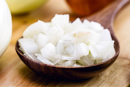 Photo for Wooden spoon with grated organic onion, vintage rustic cuisine, seasoning ingredients being prepared , macro photography - Royalty Free Image