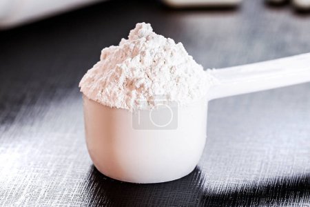 Photo for Spoon of creatine, recommended supplement to increase strength, power and muscle mass. - Royalty Free Image